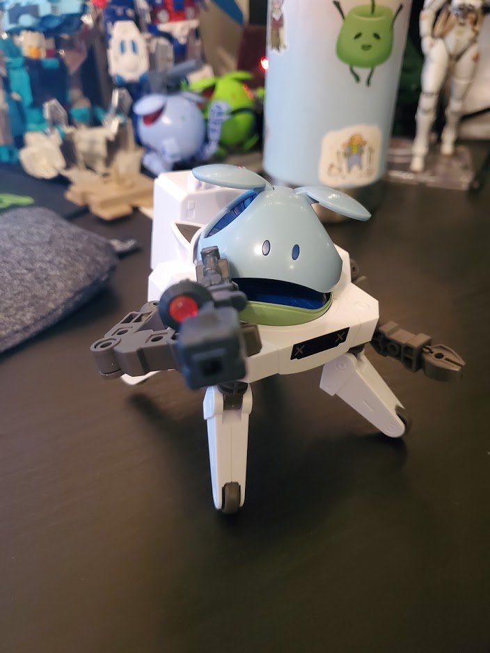 Photo of a Haro model kit: the Haro is in a white mech suit, its mouth slightly open, and is pointing a large gun directly at the camera.